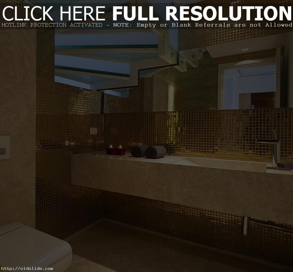 Luxury-bathroom-with-gold-mosaic-tile-wall-and-frosted-glass-stairs-above-also-marble-vanity