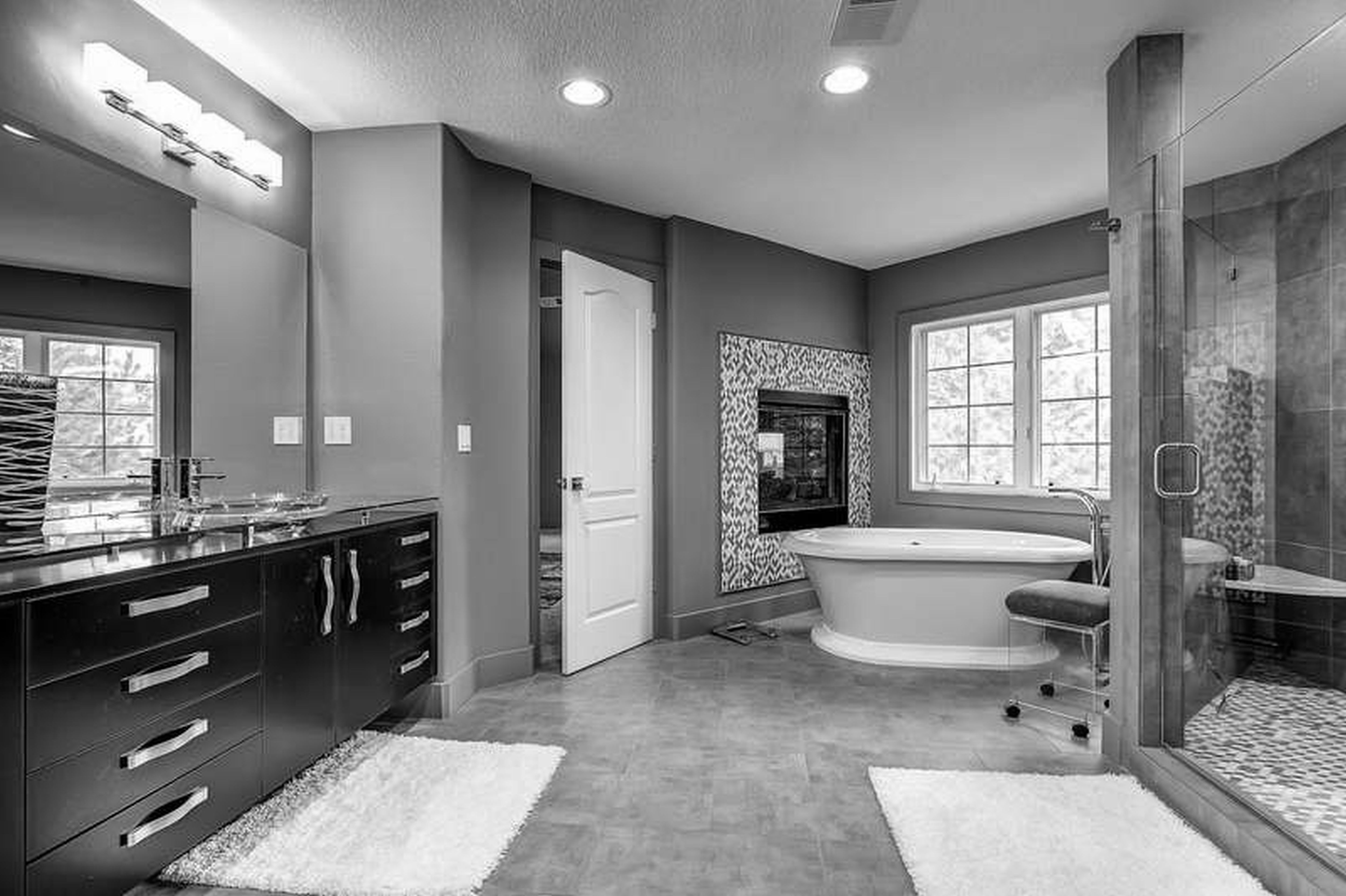 bathroom-black-wooden-bathroom-vanity-and-large-mirror-on-grey-wall-connected-by-white-bathtub-on-grey-tile-floor-bathroom-decorating-ideas-black-and-white-make-your-bathroom-look-contempor