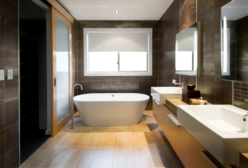 Australian Luxury bathroom with brown tiles and hardwood floor, focusing on a free standing bath. Clipping path around the windows and reflections in mirror/door.