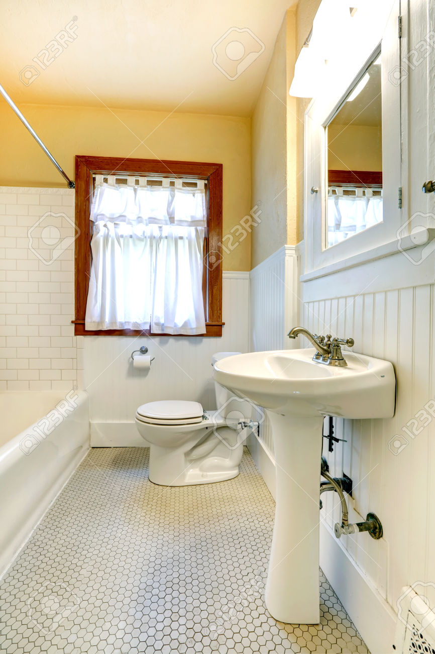 Bathroom with wood plank paneled wall and tile trim wall