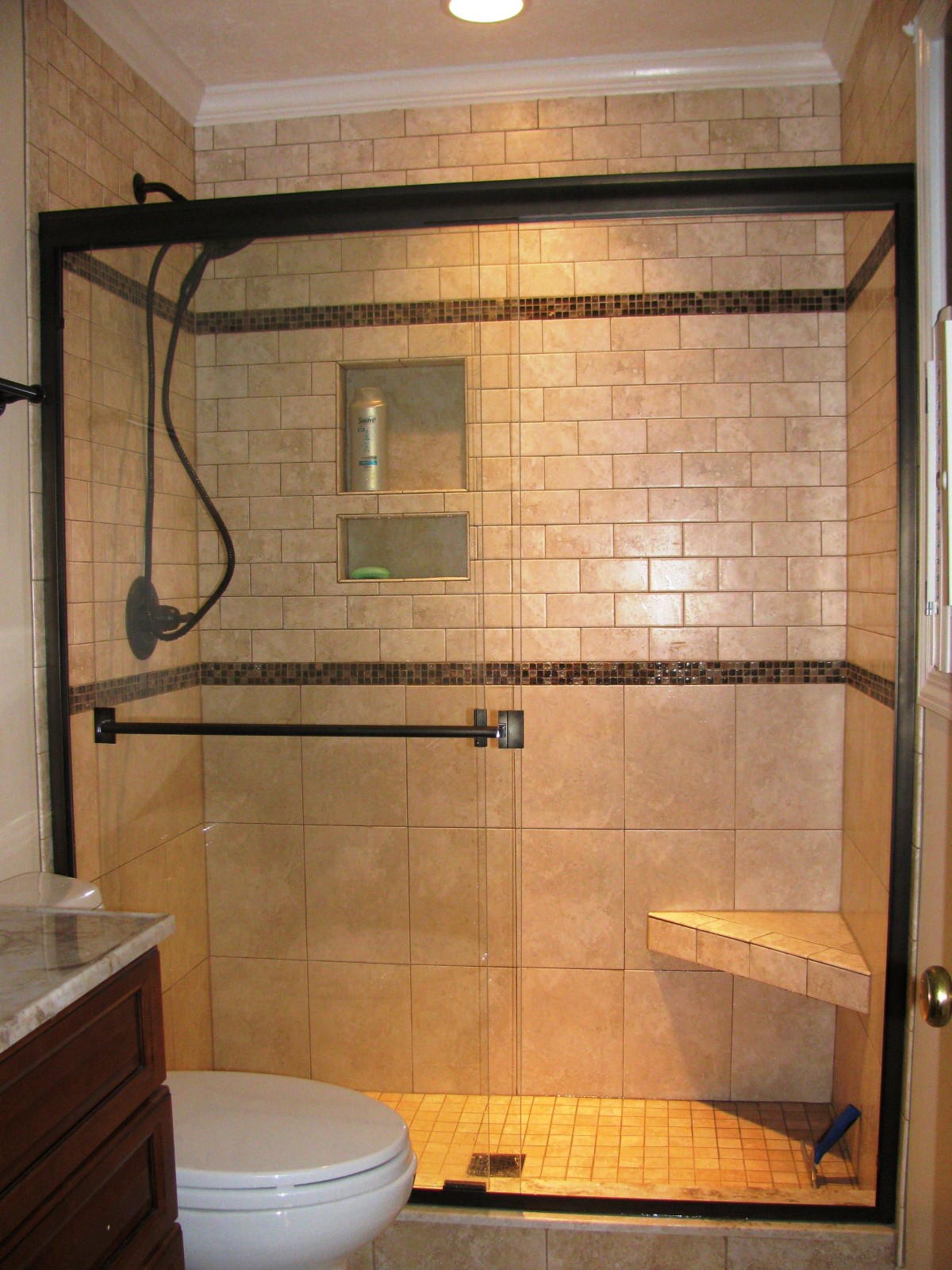 ceramic-subway-bathroom-wall-tile-shower-head-glass-cabin-partition-walls-with-black-frame-corner-bath-seat-brown-small-vanity-the-latest-styles-and-designs-of-bathroom-showrooms-1200x1600