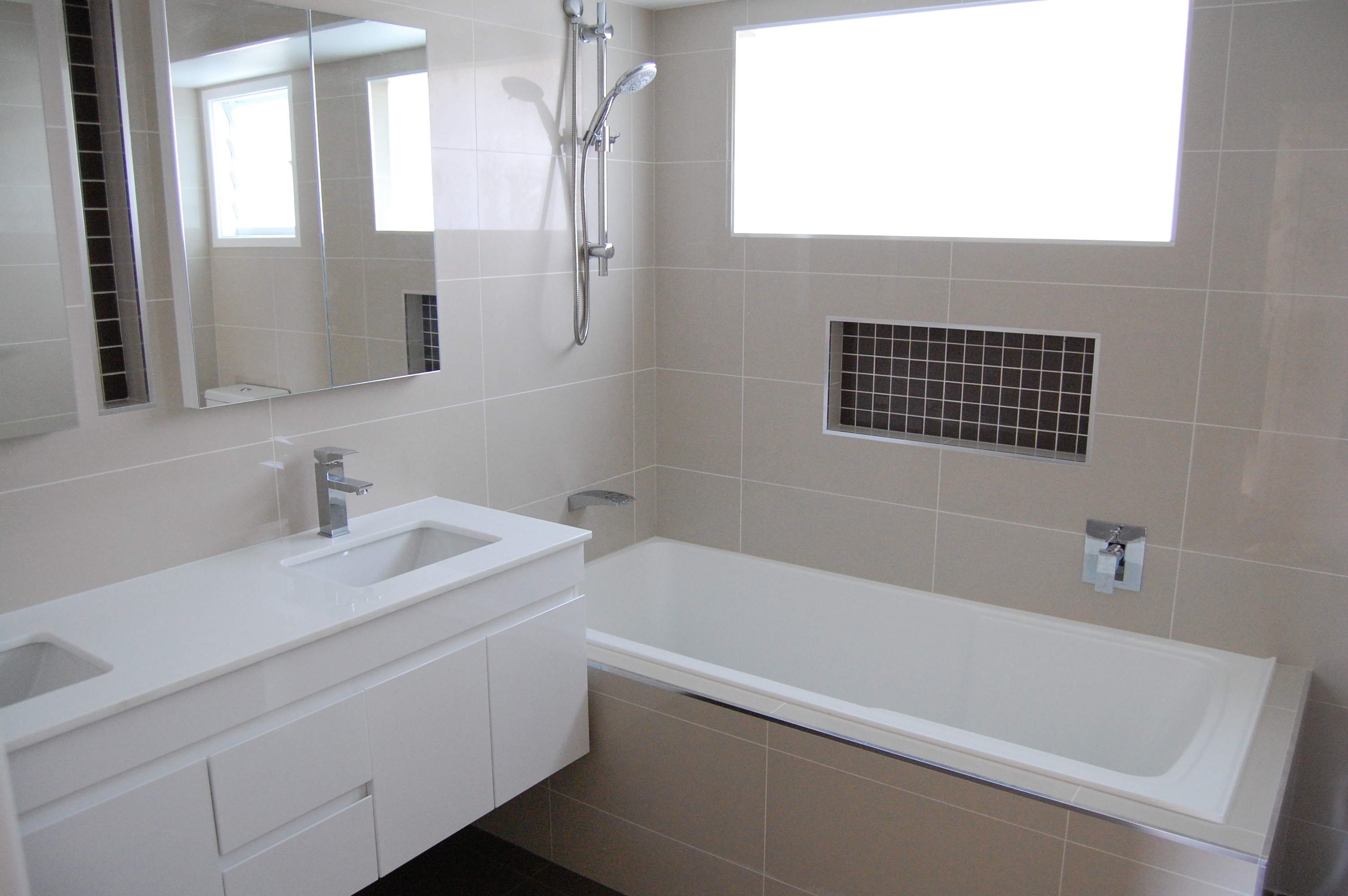 Neutral-Bathroom-With-Ceramic-Tile-Floor-With-Wash-Hasn-Double-Small-Mirror-With-White-Bathtub